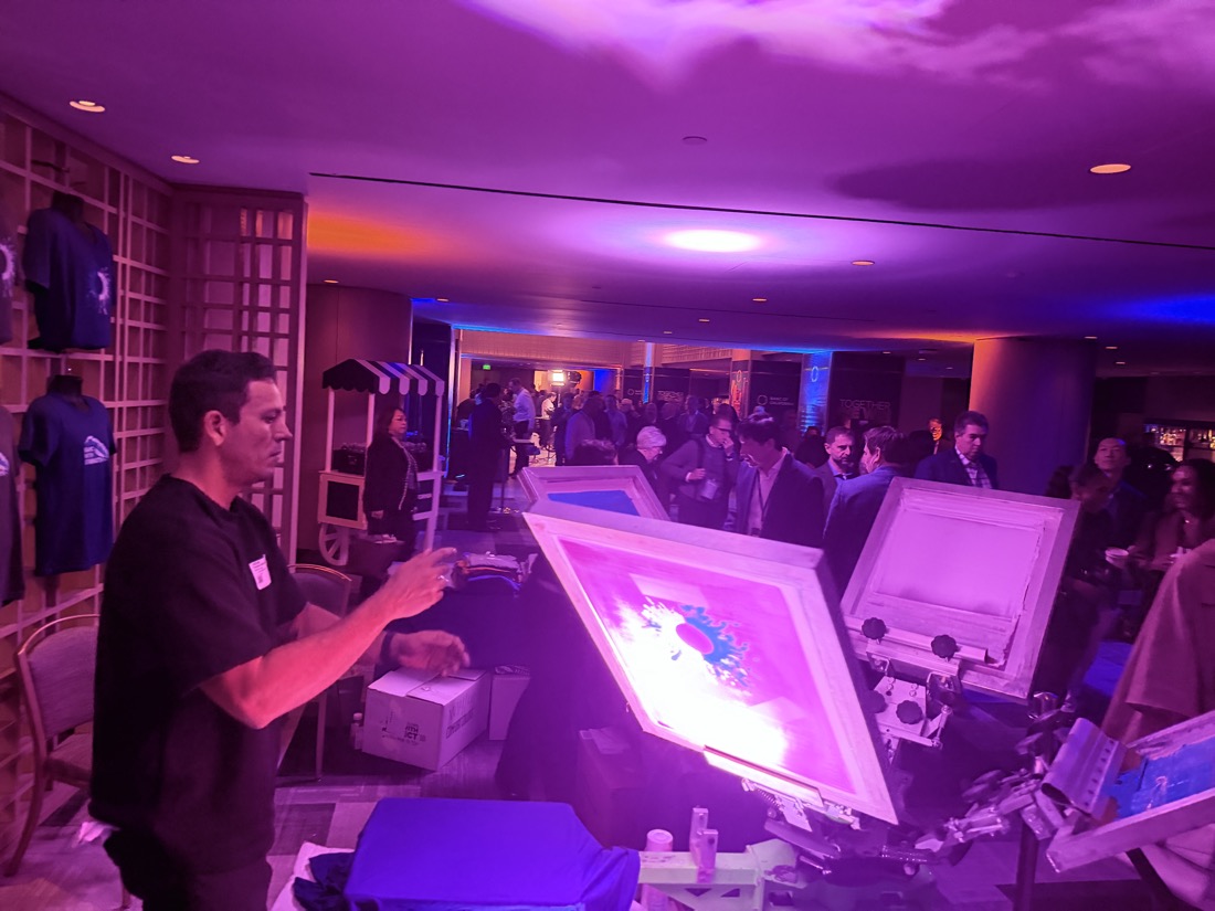 Evening brand activation with live printing under purple lighting at a hotel venue